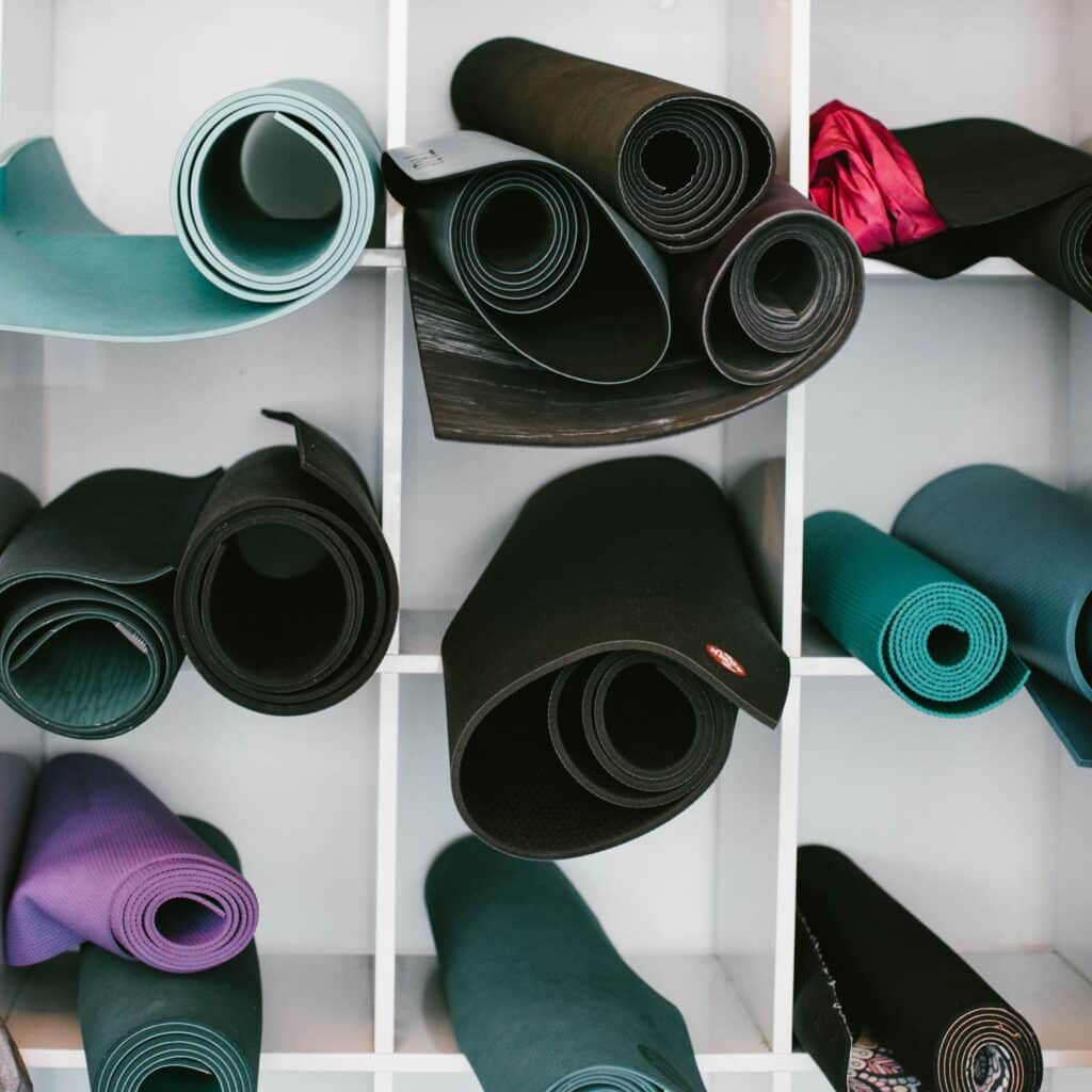 shelving with rolled sustainable yoga mats on it