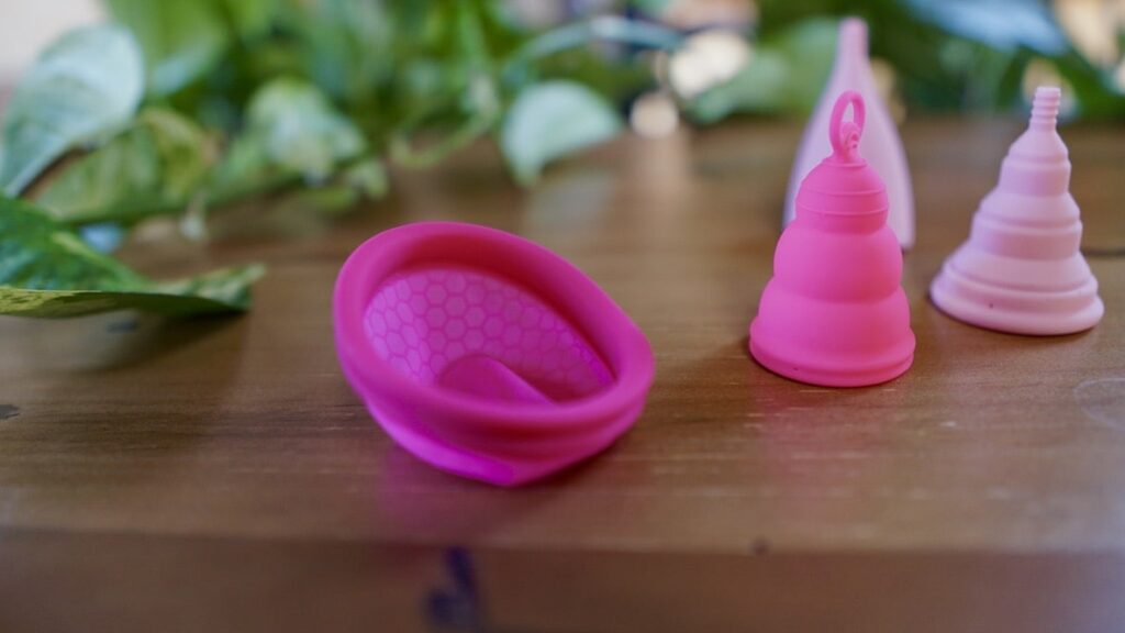 menstrual cups benefits - a period disc and various cups on a counter