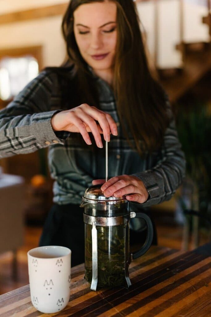 screen detox - a woman making tea to relax as part of her screen detox.