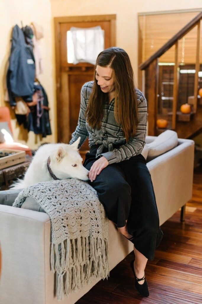 How to do a digital detox: a woman in a mountain cabin with her dog.